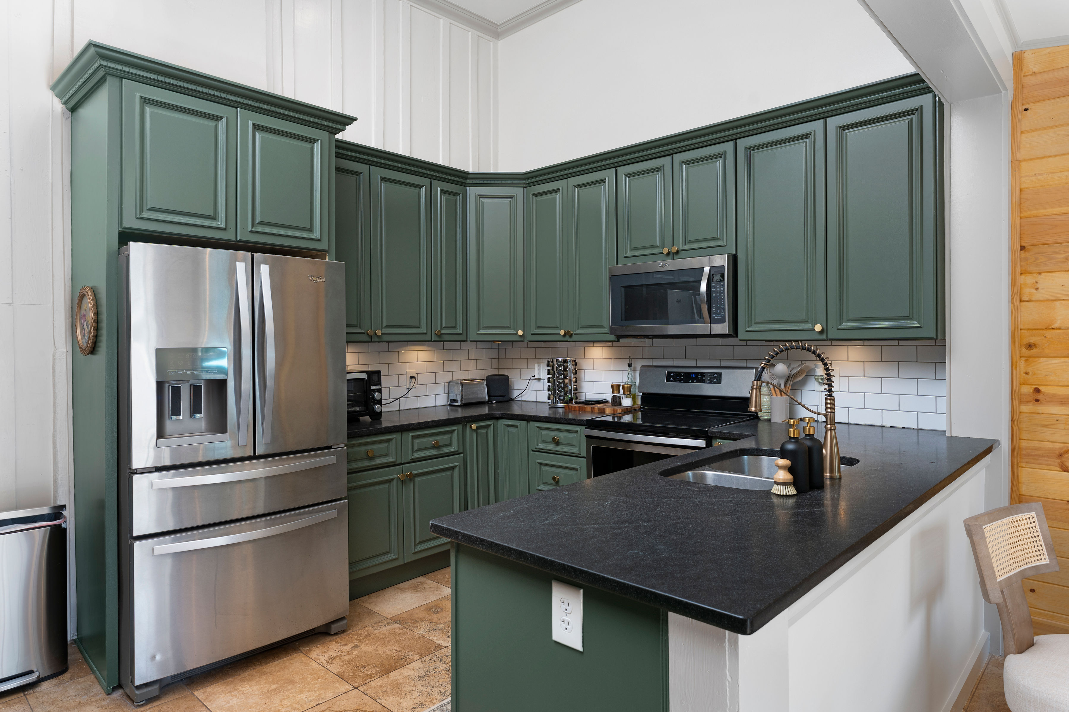Forest green kitchen with stainless appliances
